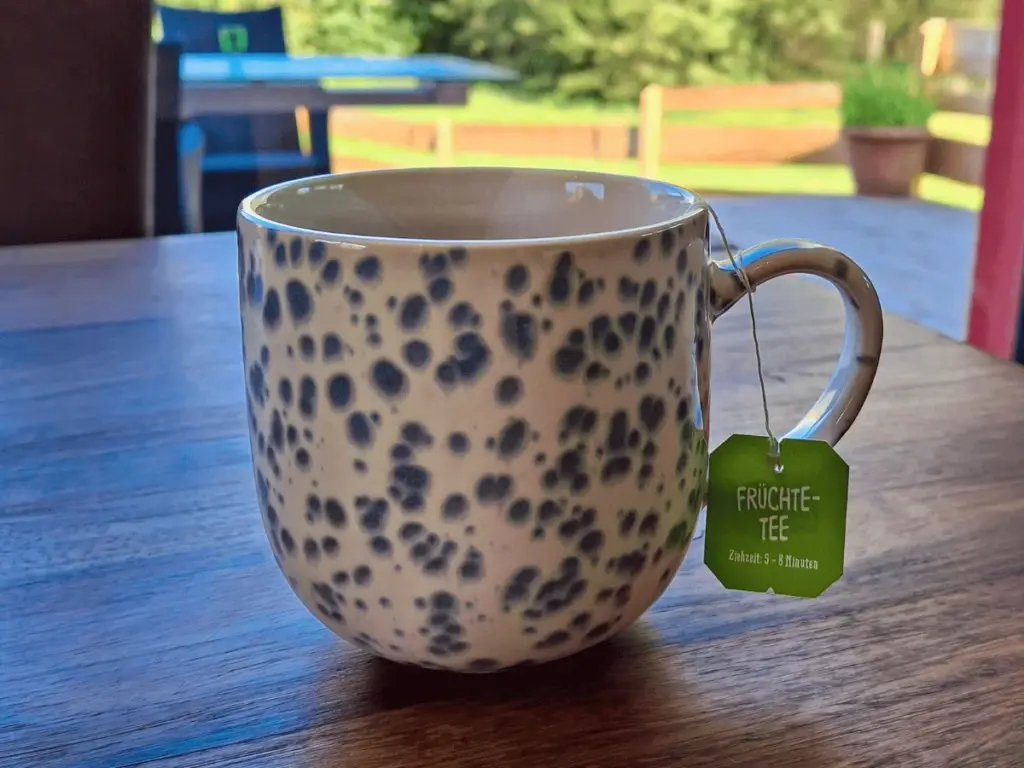 Gespräch mit Angehörigen in ruhiger Atmosphäre – Früchtetee in Seewald Beschreibt den Inhalt präzise und emotional passend zum Thema.
Eine dampfende Tasse Früchtetee auf einem Holztisch vor sonnigem Gartenhintergrund – Symbol für ruhige Gespräche mit Angehörigen in entspannter Atmosphäre.