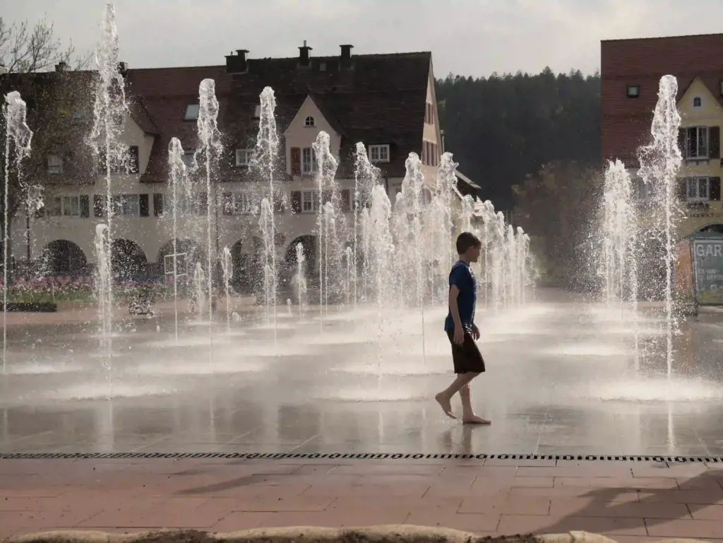 Kind läuft barfuß durch Wasserfontänen am Marktplatz Freudenstadt – ständige Anspannung im Körper kann sich lösen